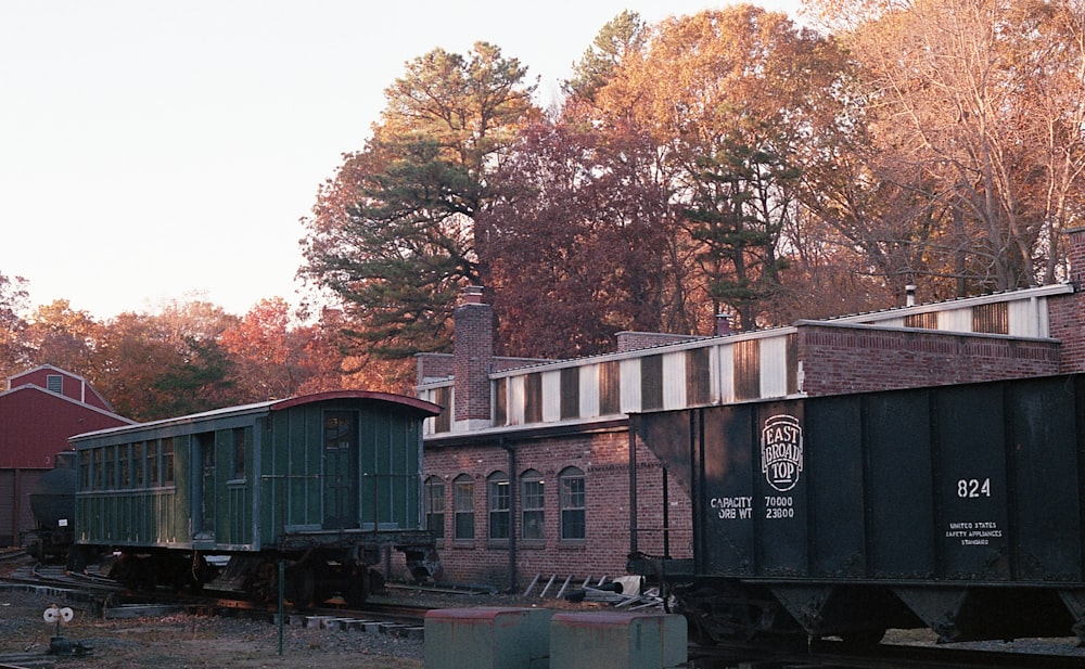 a train car sitting on the tracks in front of a building