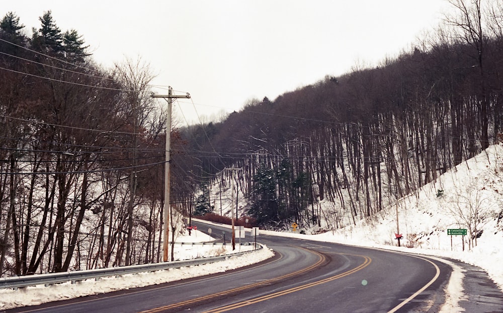 eine schneebedeckte Straße mitten in einem Waldgebiet