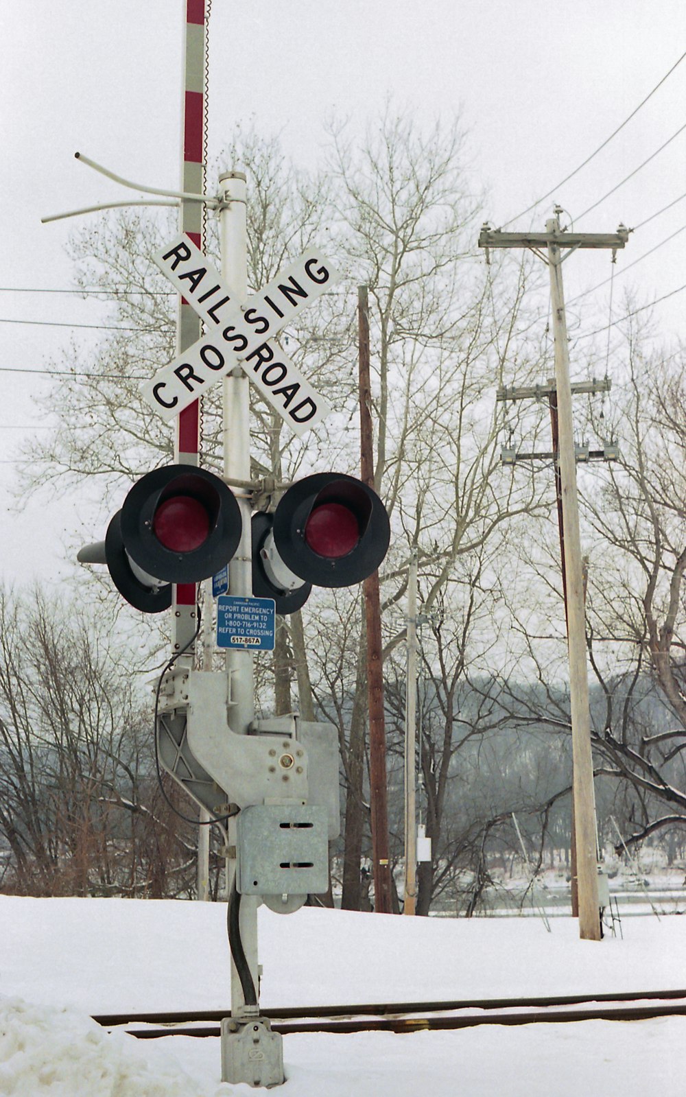 a railroad crossing signal in the snow