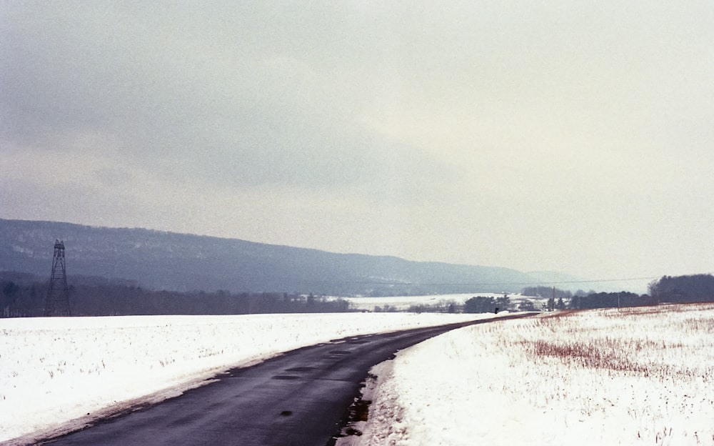 a road in the middle of a snowy field