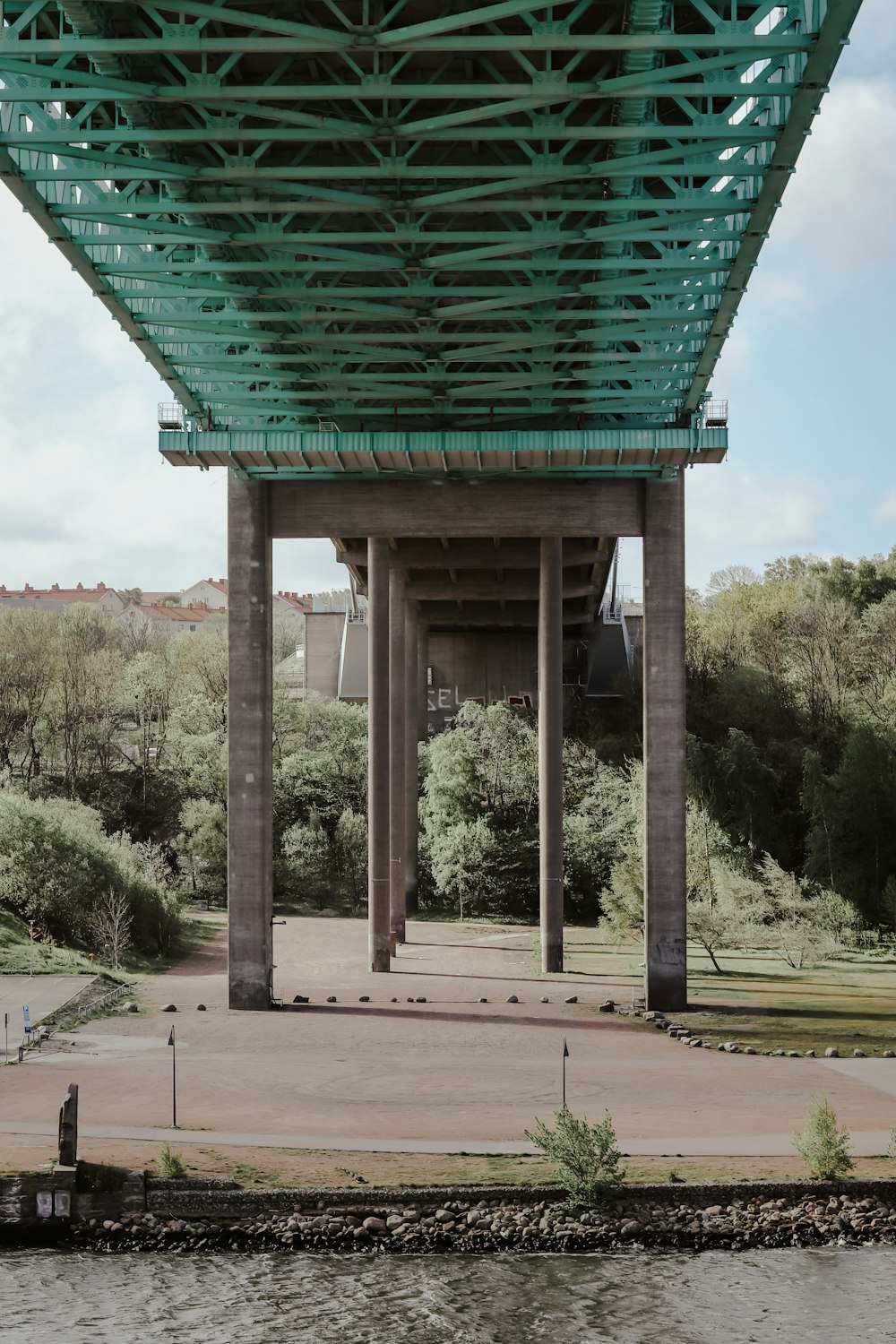 uma vista da parte inferior de uma ponte sobre um corpo de água