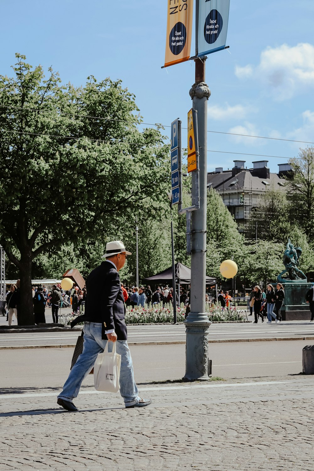 a man walking down a street next to a street sign