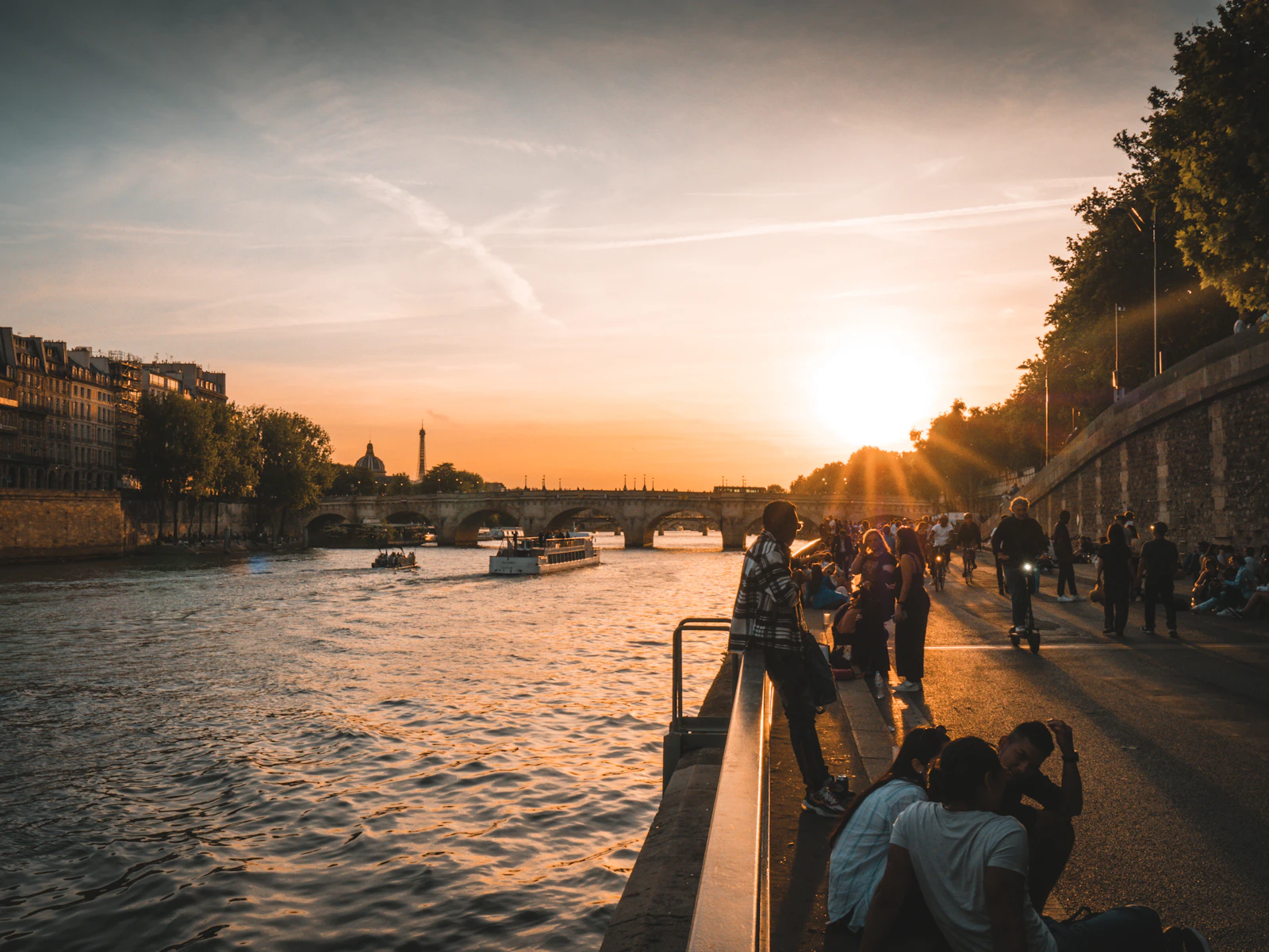 People sitting beside the Seine in Paris