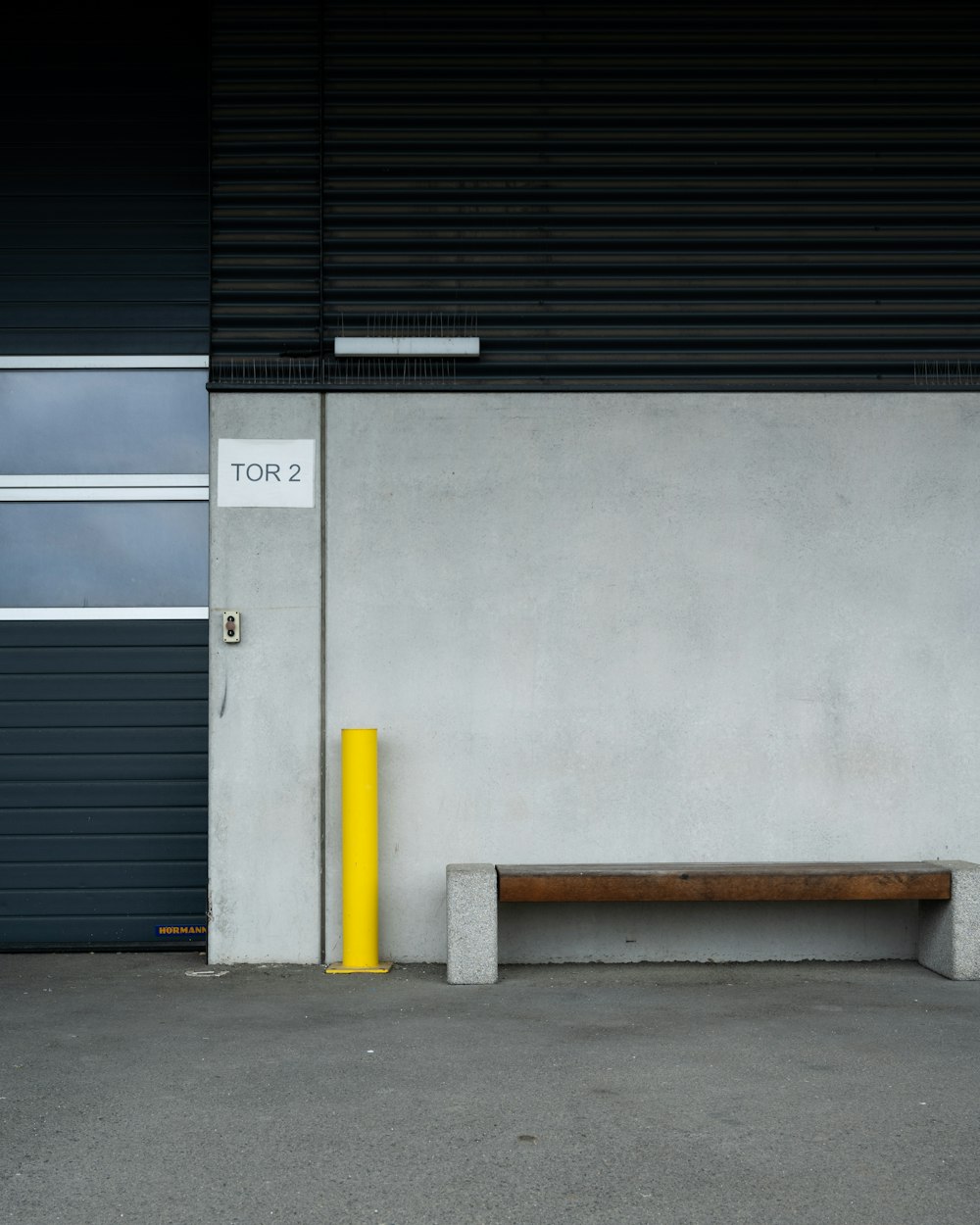 a yellow pole sitting next to a gray building