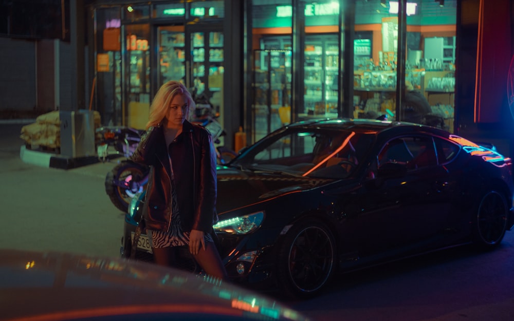 a woman standing next to a car in a parking lot