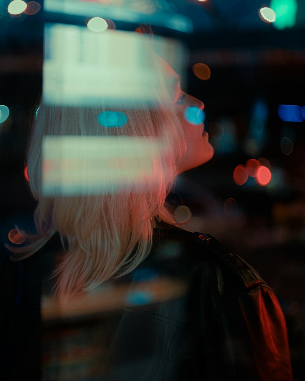 a woman standing in front of a window at night