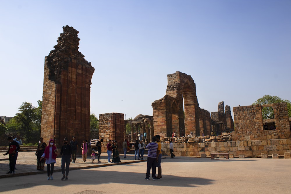 a group of people standing in front of a stone structure