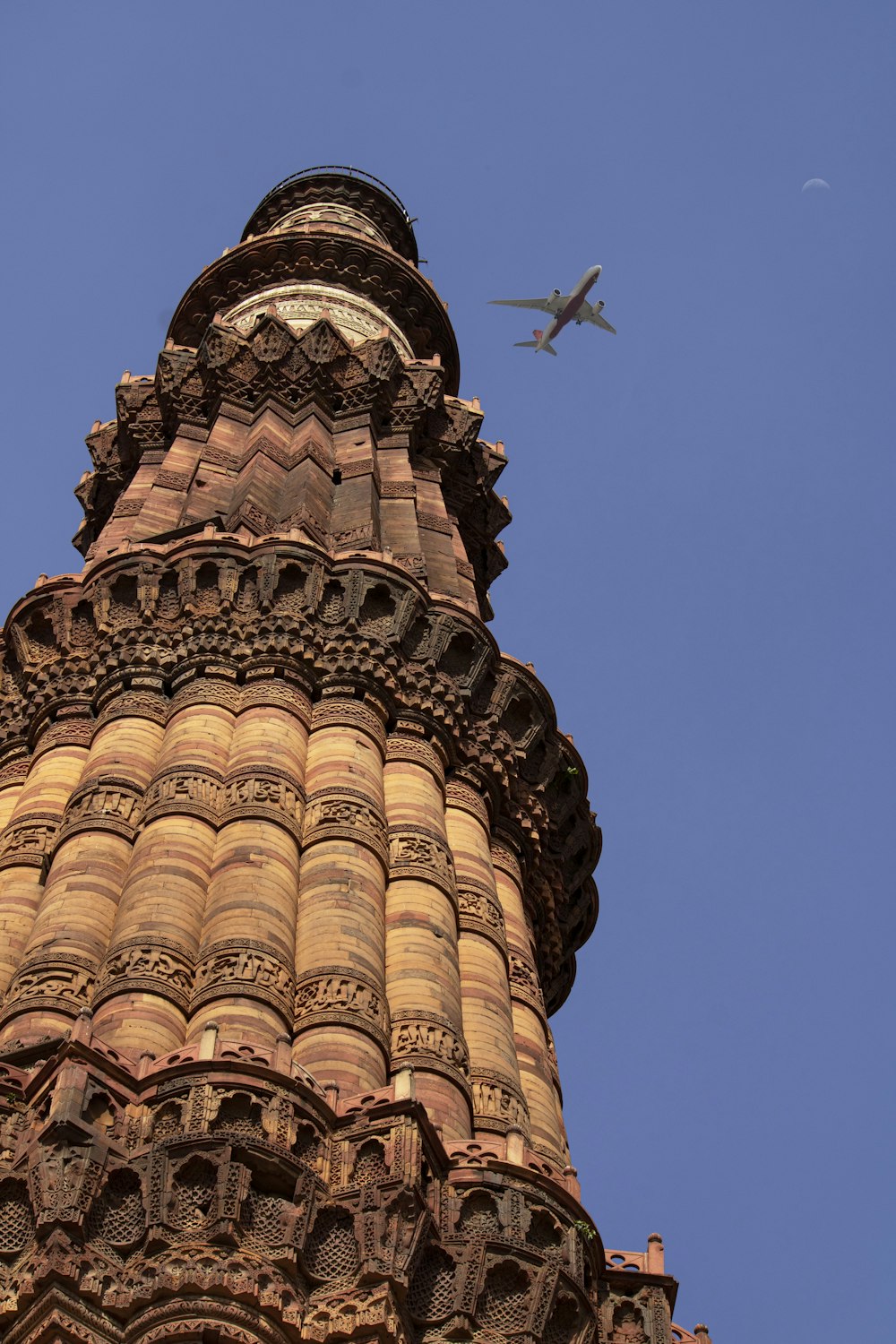 an airplane is flying over a tall tower