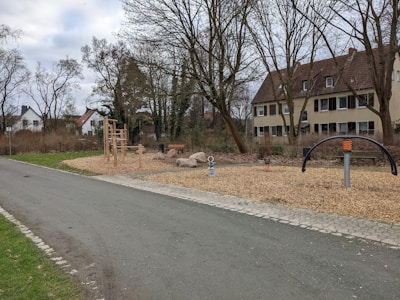 A community playground surrounded by trees and walking paths at Vrindavan Dhaam.