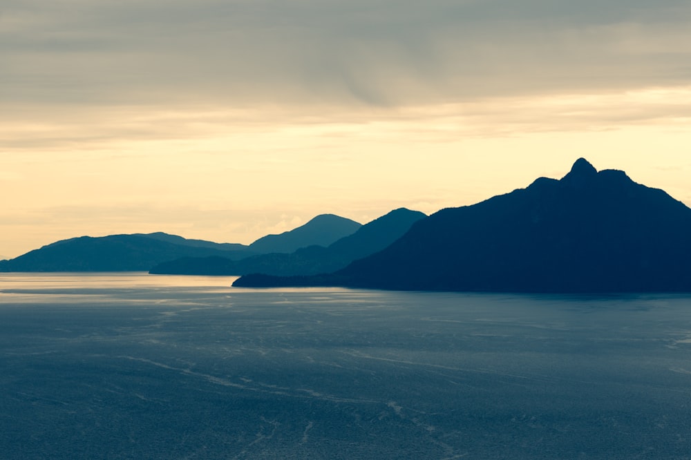 a large body of water with mountains in the background