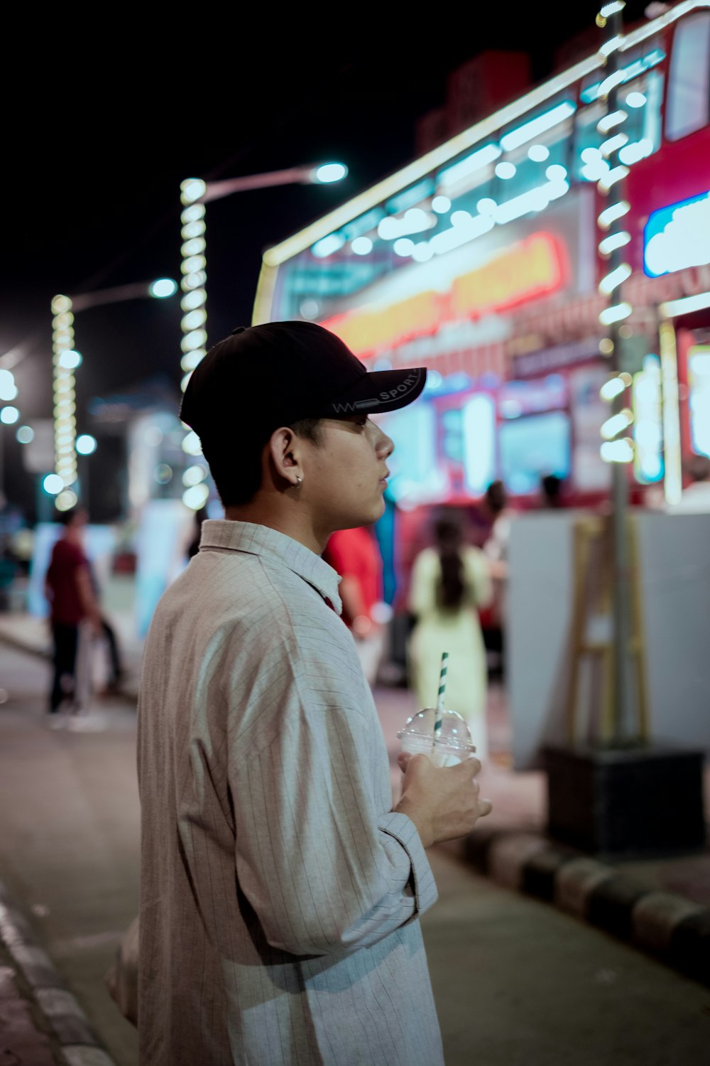 a man standing on the side of a street at night