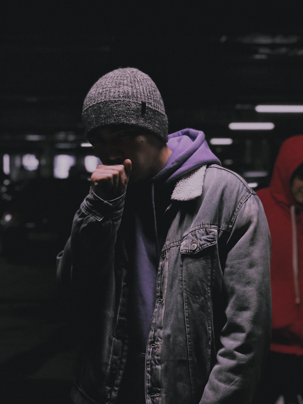 a man standing in a parking garage talking on a cell phone