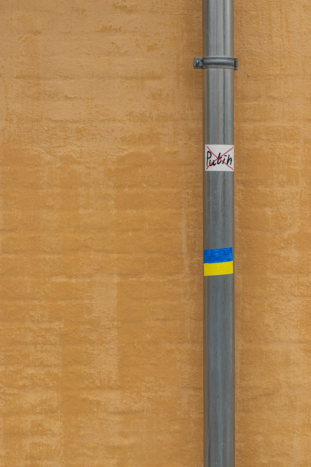 a pole with a sticker on it next to a wall