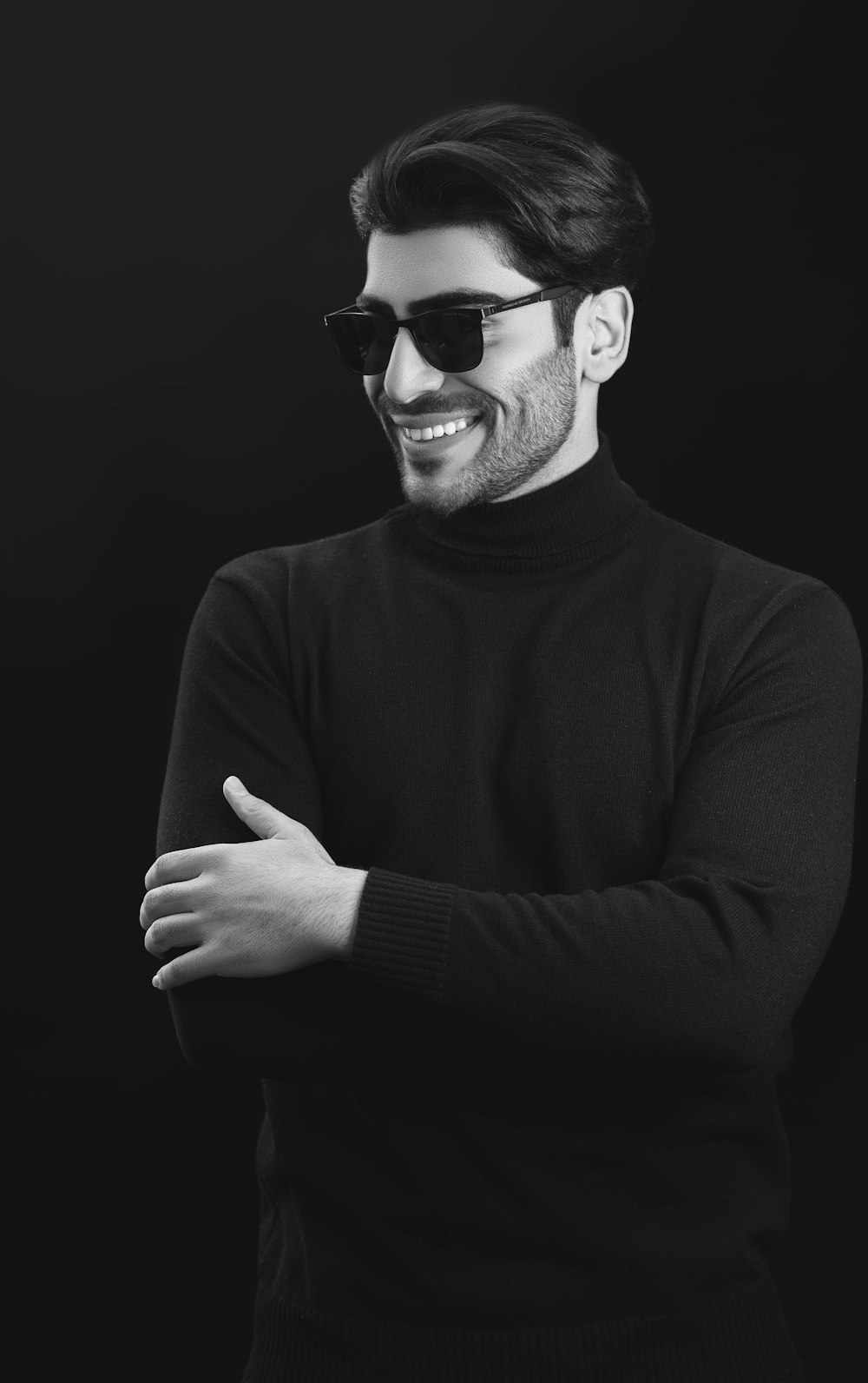 a man wearing sunglasses and a turtle neck sweater