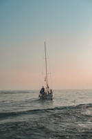 A family learning to sail together on a calm sunny day with a small sailboat.