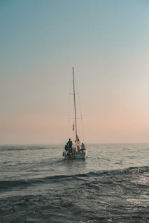 A small group learning the ropes during a hands-on basic sailing lesson on calm waters.