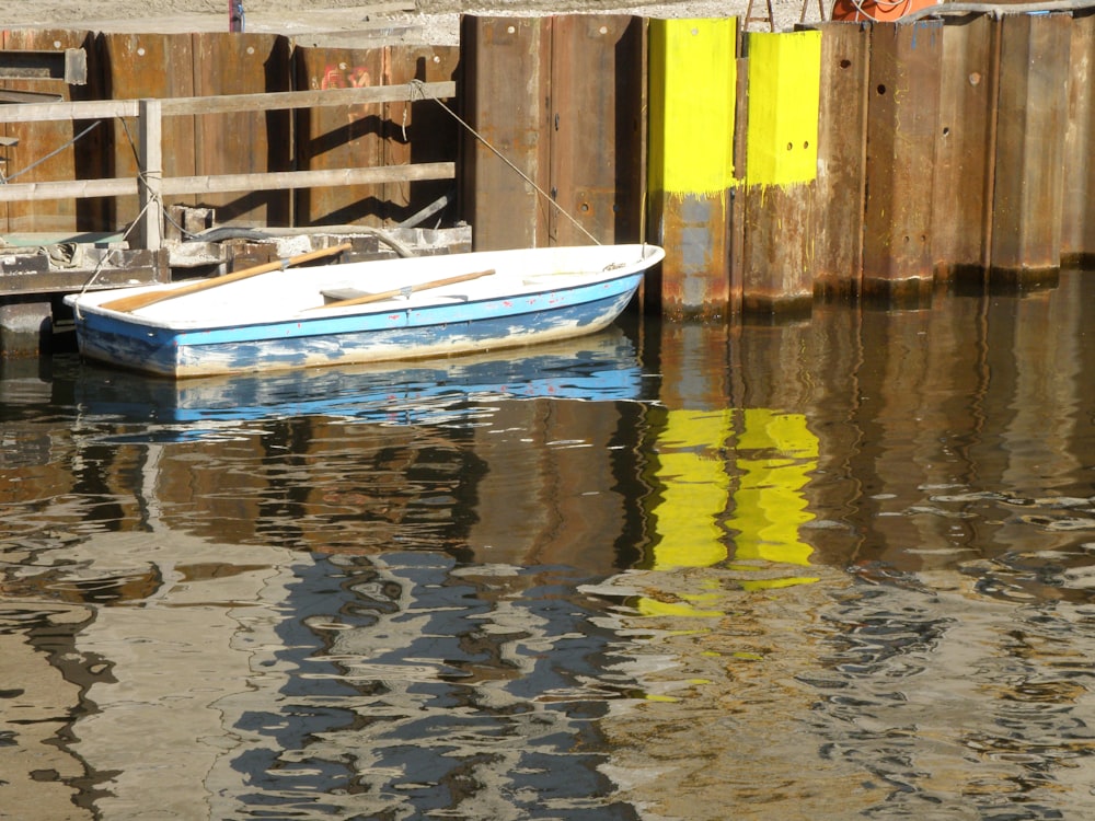 a small boat sitting in the water next to a dock