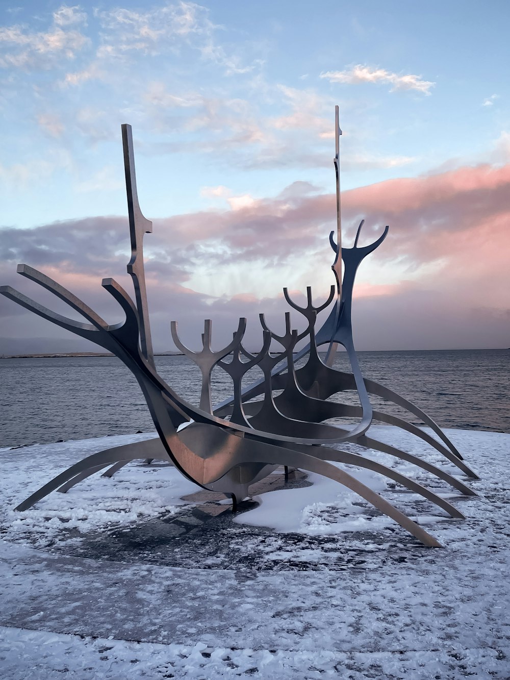 a sculpture of a group of people standing on top of a snow covered ground