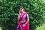 a woman in a pink and purple sari talking on a cell phone