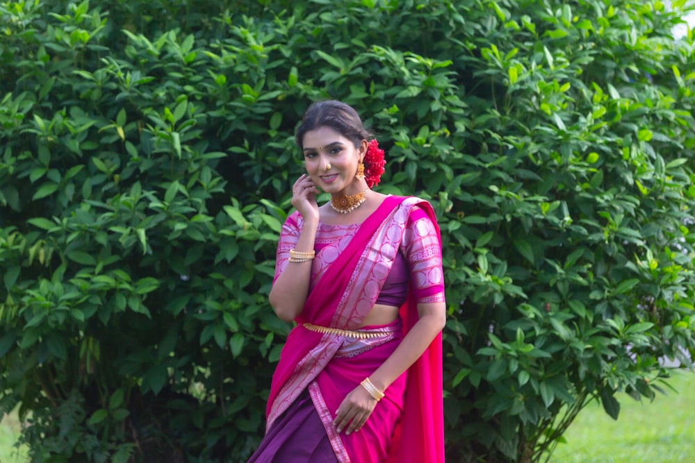 a woman in a pink and purple sari talking on a cell phone