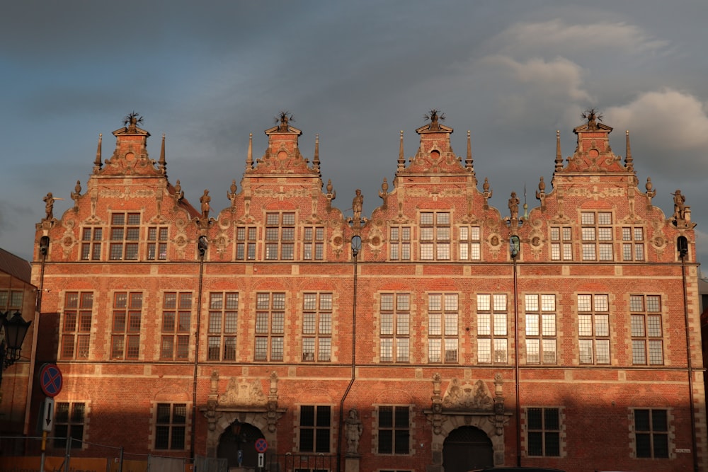 a large brick building with many windows and a sky background
