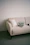 Laptop on a cream sofa with a pillow.
