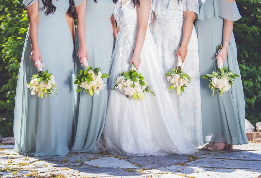 a group of women standing next to each other holding bouquets