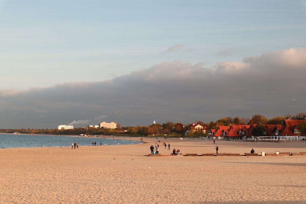 a group of people standing on top of a sandy beach