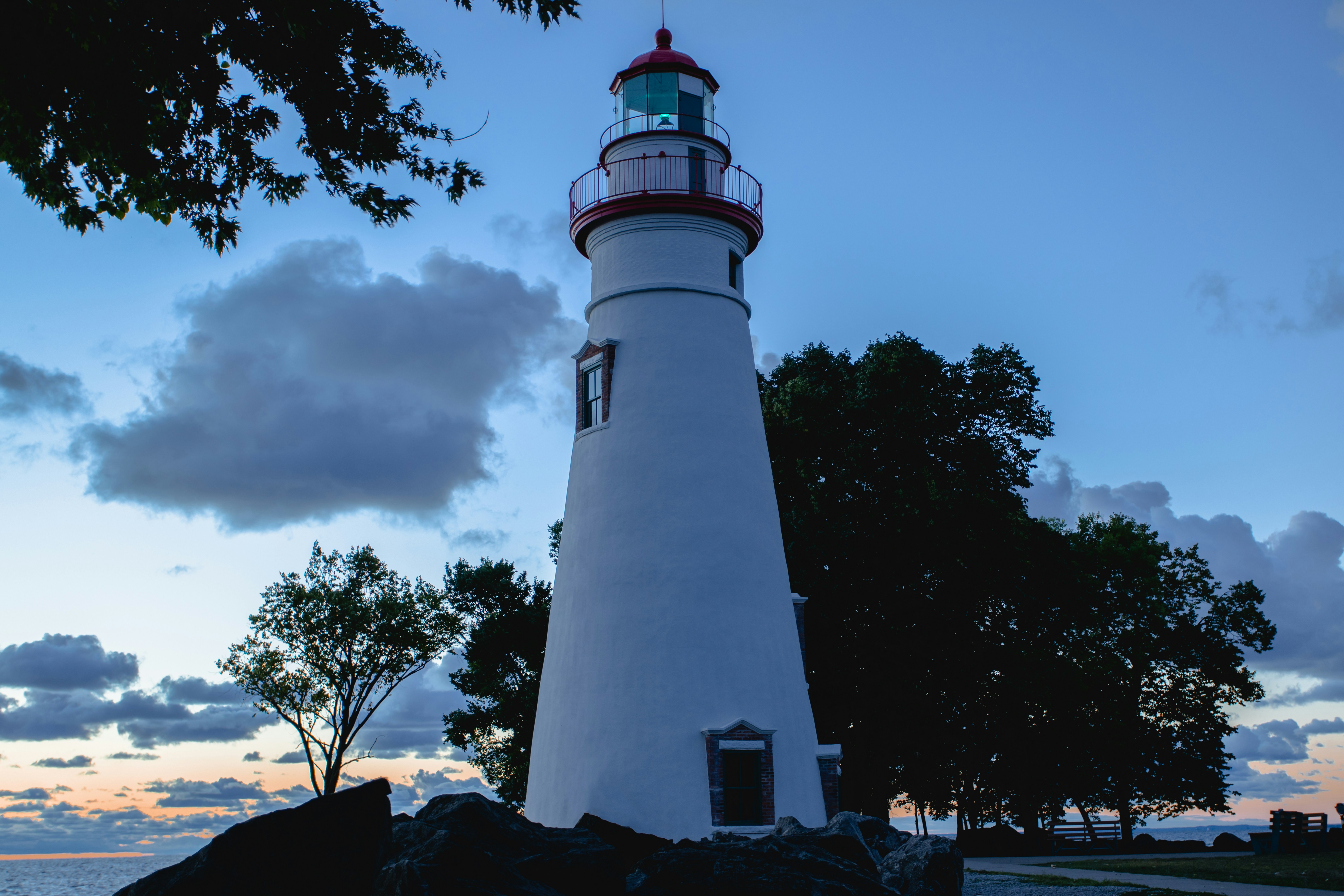 a white and red lighthouse sitting on top of a rock