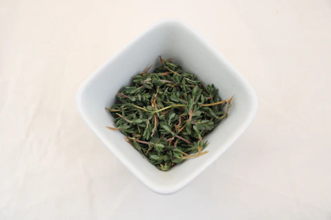 a white bowl filled with green tea on top of a white table