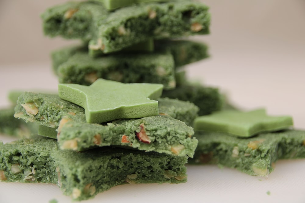 a pile of green desserts sitting on top of a white plate