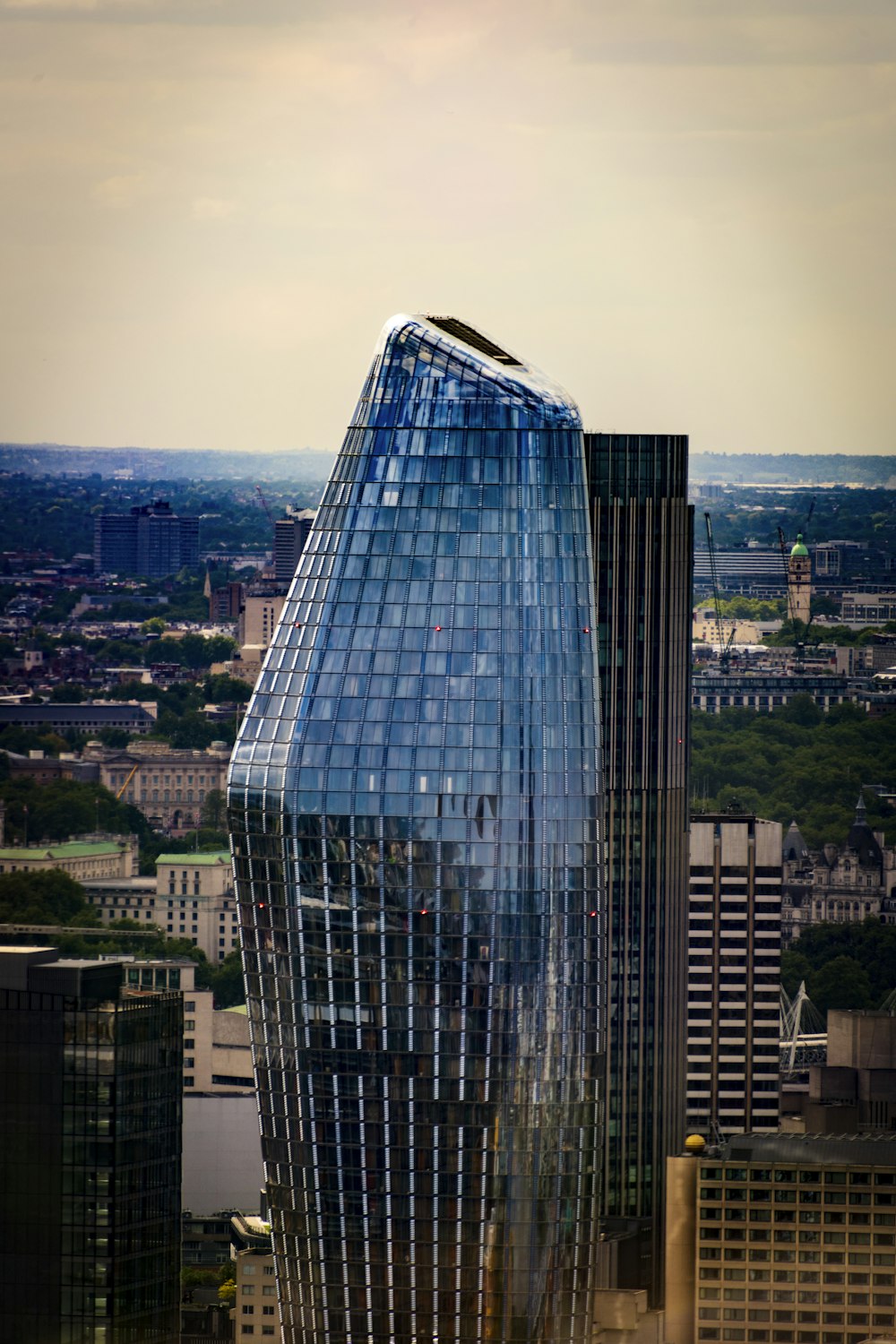 a very tall glass building in the middle of a city