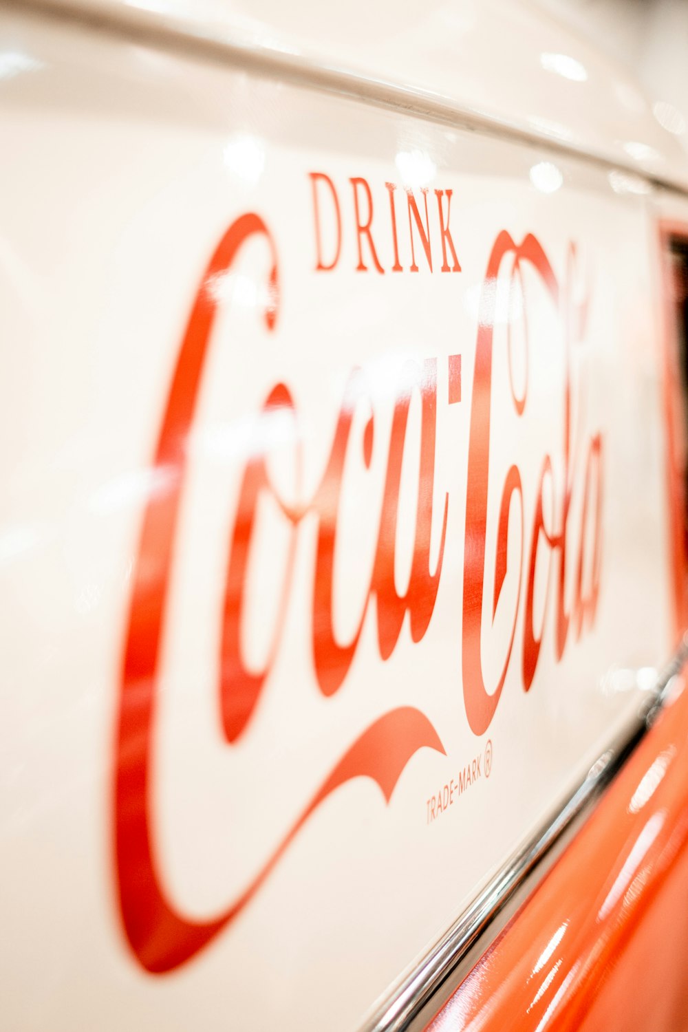 Un primer plano de un letrero de Coca Cola en un automóvil