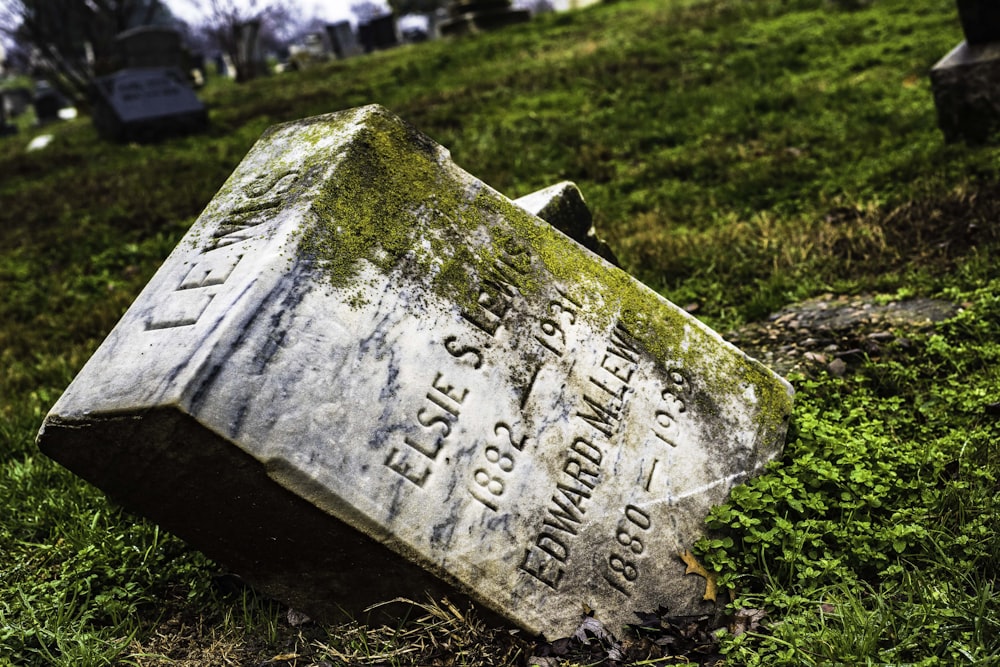 Una tumba en la hierba con una lápida en el fondo