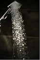 a close up of a shower head with water coming out of it