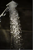 a close up of a shower head with water coming out of it
