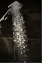 a close up of a shower head with water coming out of it