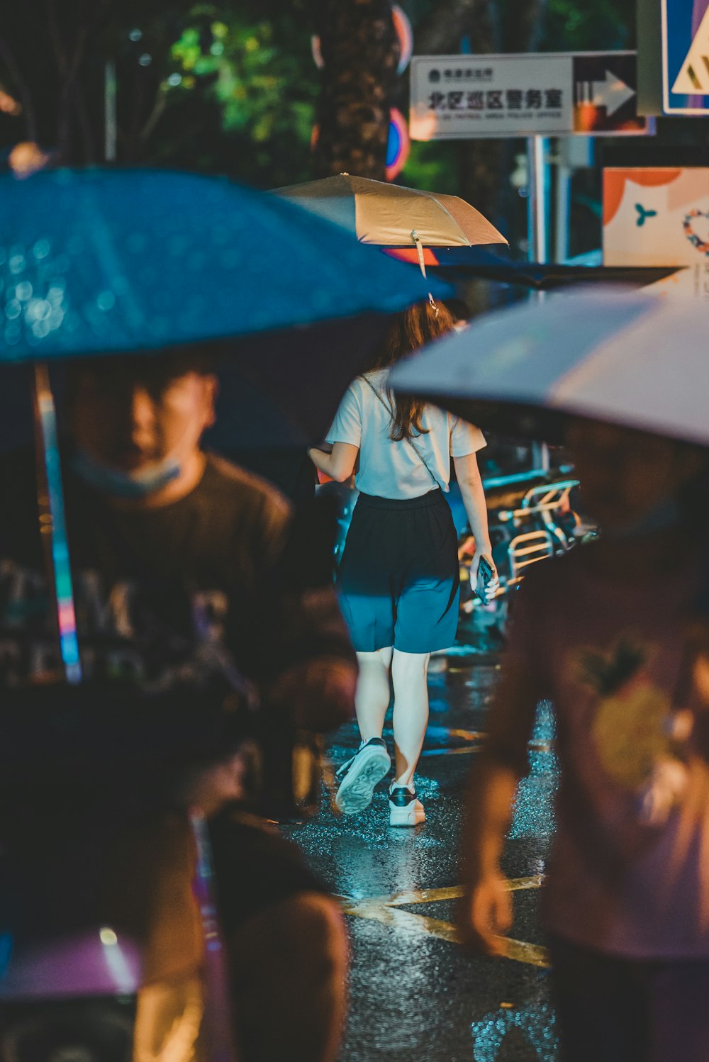 a group of people walking down a street holding umbrellas