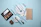 Elegant flat lay of makeup brushes and warm neutral-toned cosmetics on a beige background.