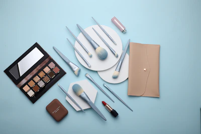 Flat lay of various eyelash styles and makeup brushes arranged on a marble surface.