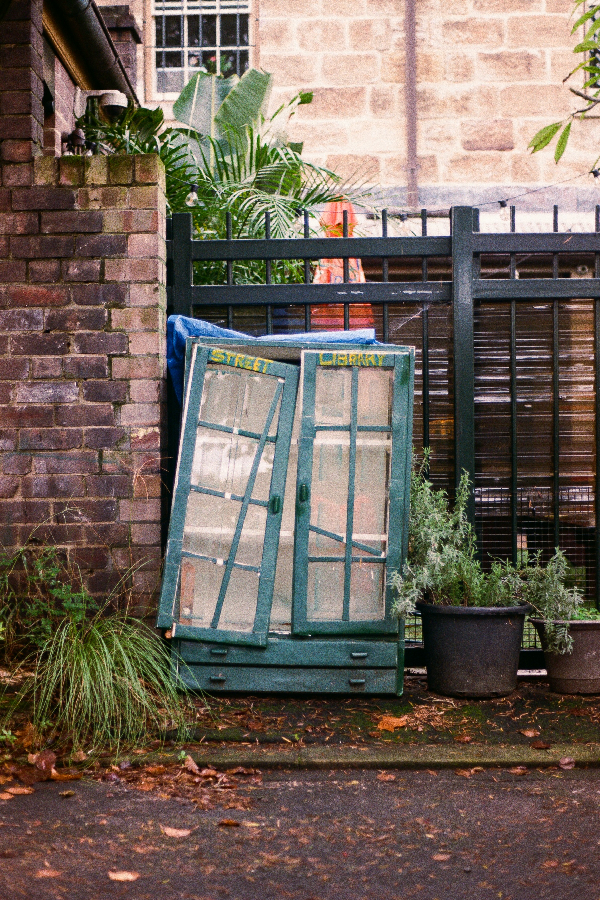 a green cabinet sitting in front of a brick building