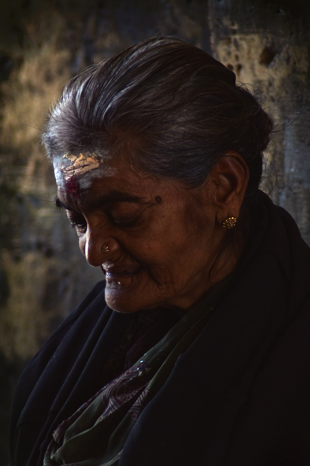 an old woman with a gold nose piece on her forehead