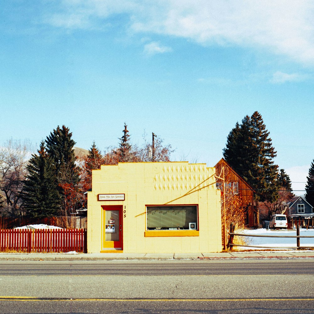 a yellow building sitting on the side of a road