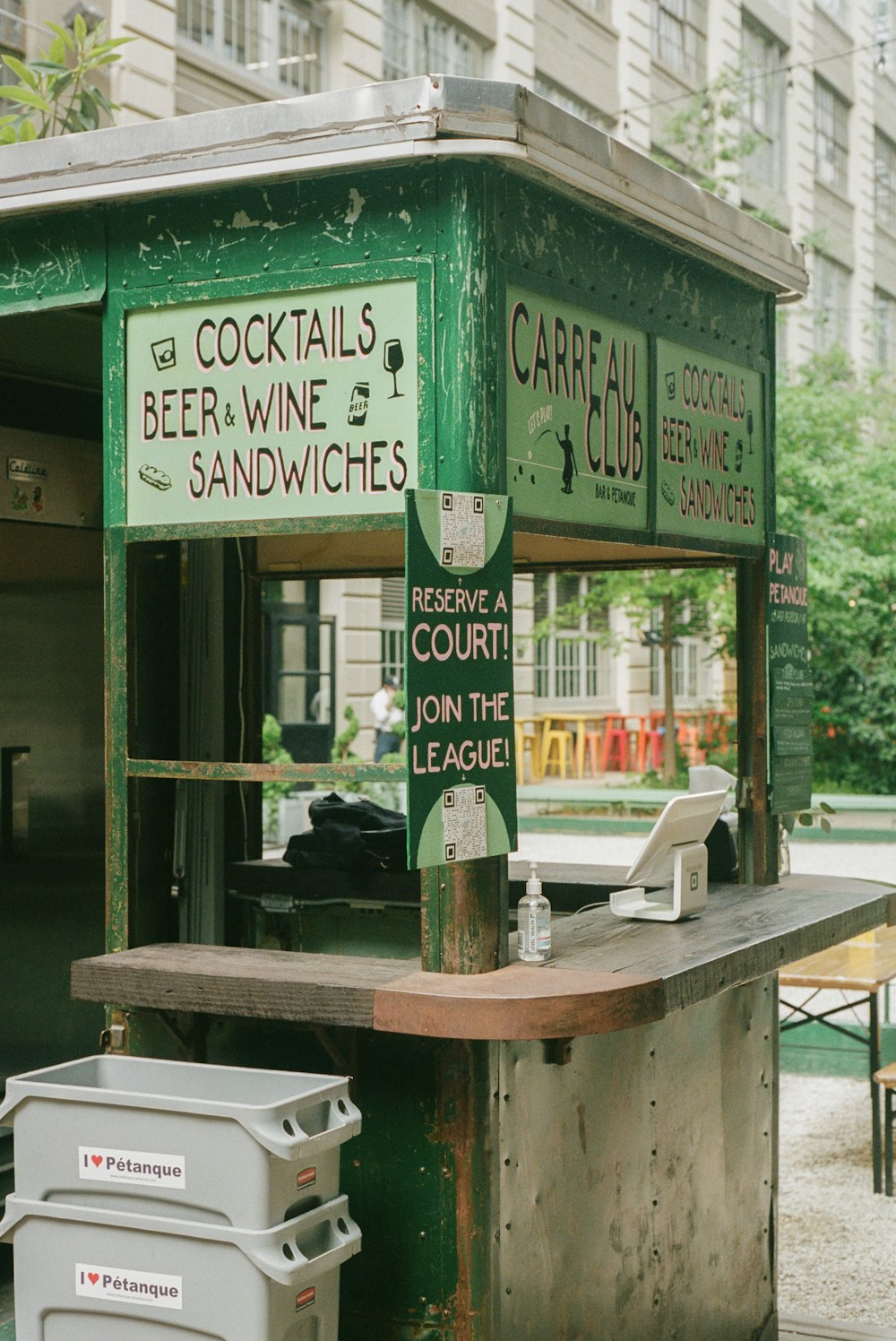 a green and white food stand on a city street