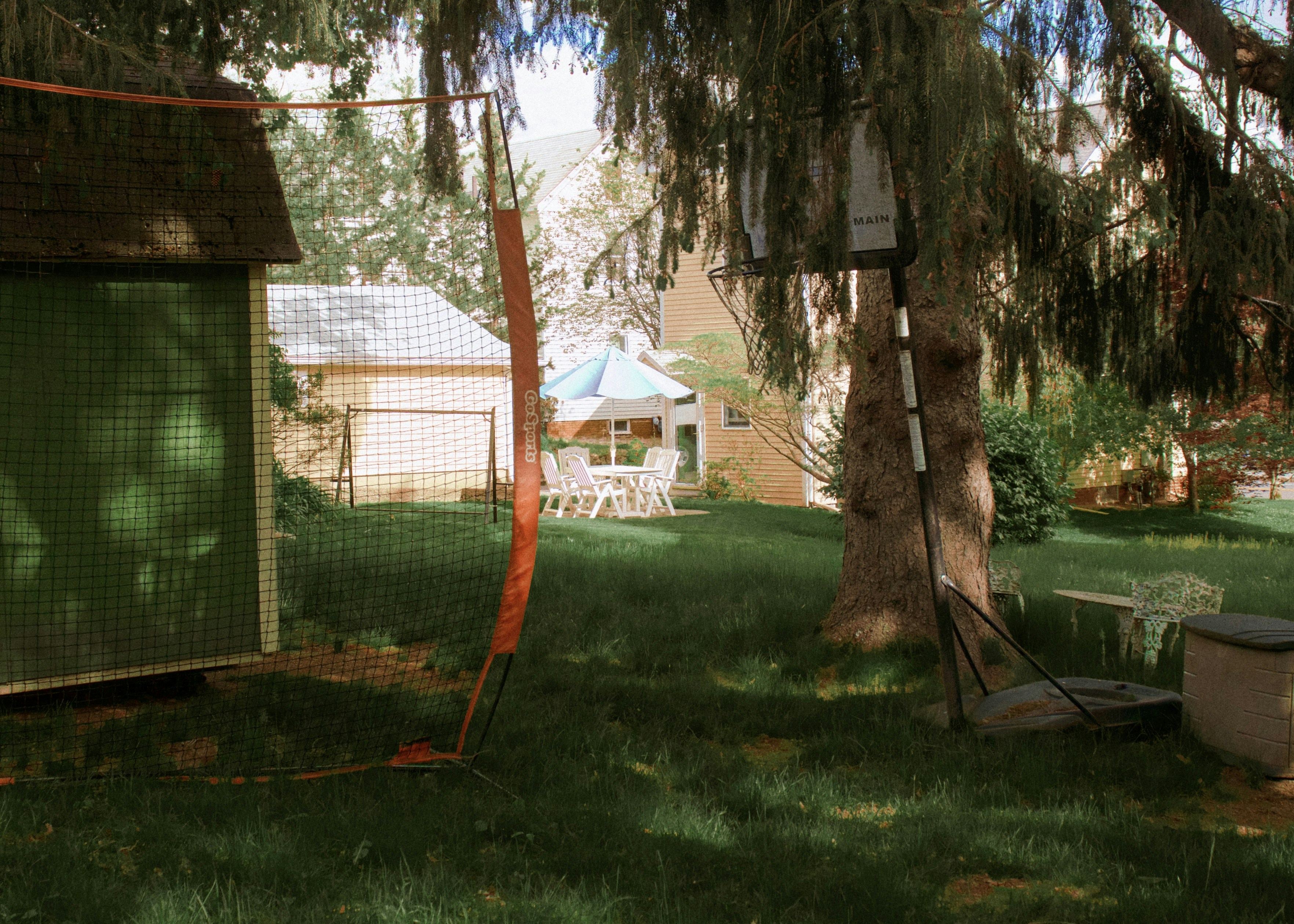 A playhouse with a slide and swing in a backyard setting