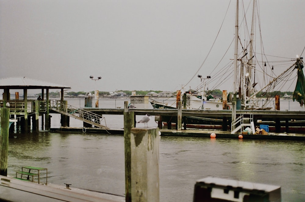 a boat is docked at a pier on a cloudy day
