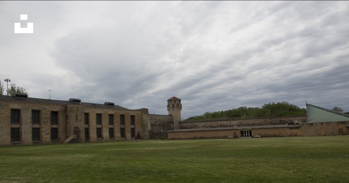 建物を背景にした広い草原の写真 Unsplashの無料古いジョリエット刑務所写真