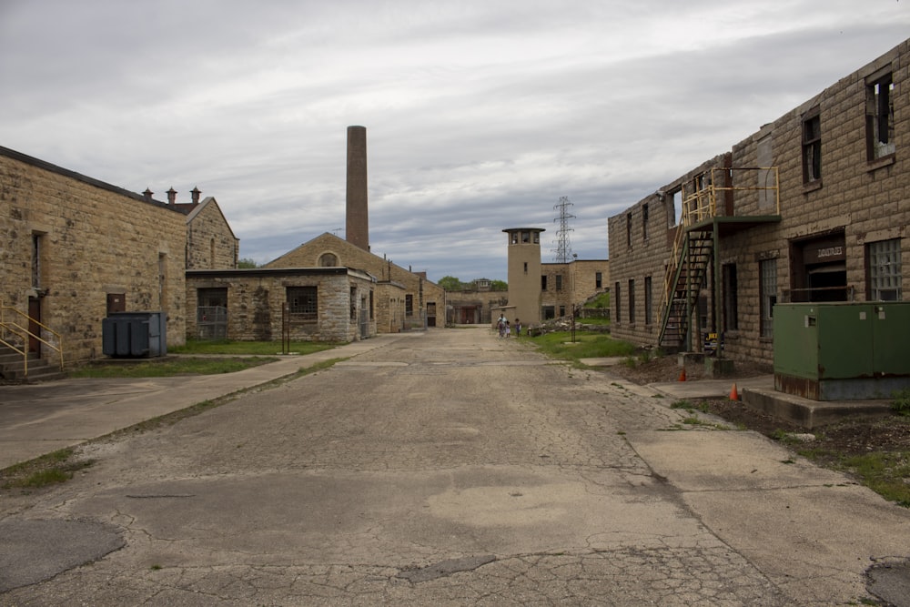 an empty street lined with brick buildings under a cloudy sky