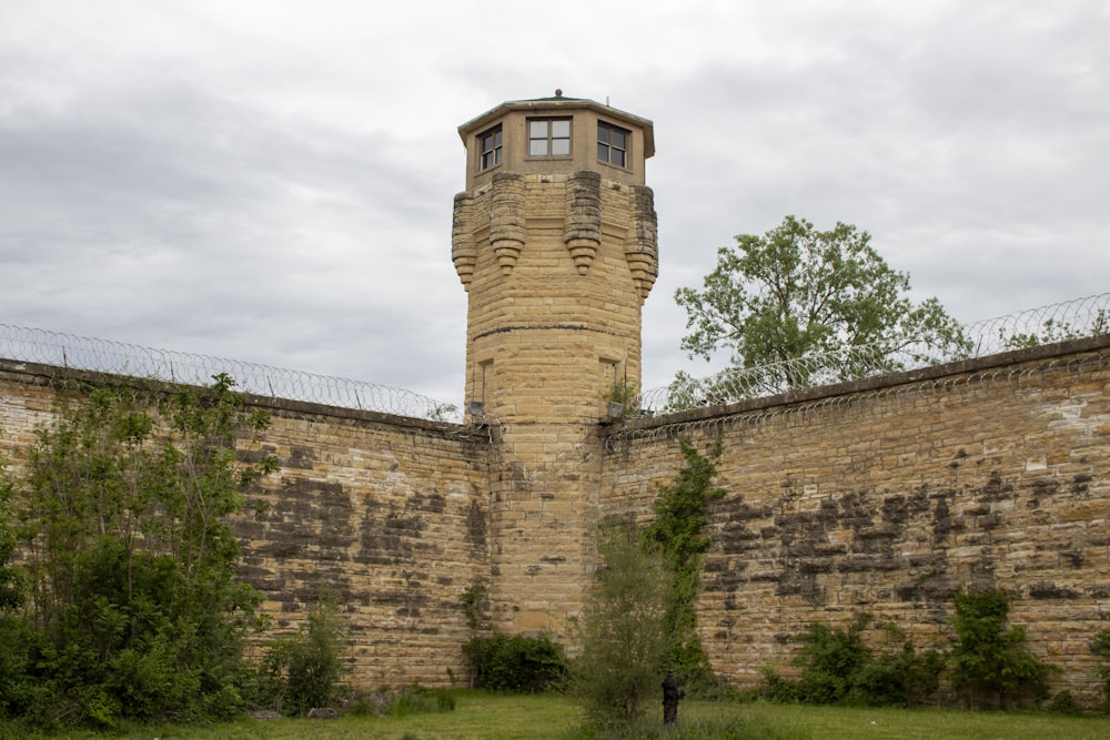 a tall brick tower sitting next to a lush green field