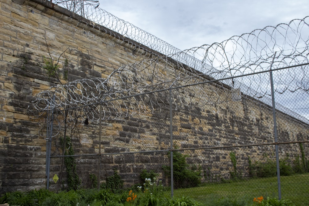 a large brick wall with razor razors on top of it